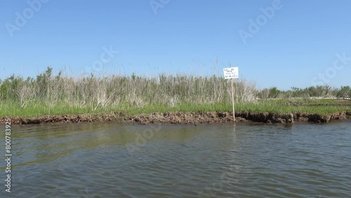 Brommes Island, Maryland USA The shore of a grassy island on the Patuxent River and a sign saying No Trespassing, No Hunting.  photo