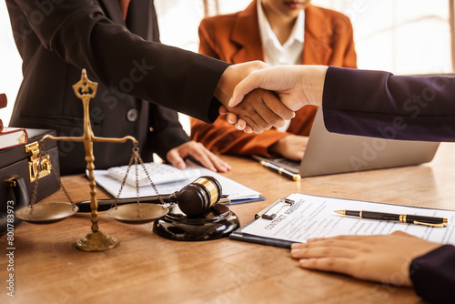 Shaking hands, Lawyers offer legal guidance, stand for clients in court, and aid with legal paperwork. analyze laws to safeguard clients' rights and interests, fair representation and justice. photo