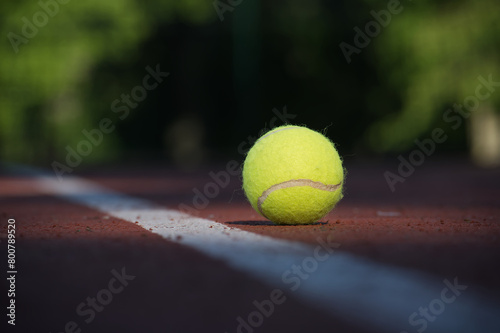 Tennis ball on hard court surface near white line