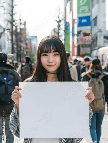 街角でホワイトボードを持つアジア人女性.