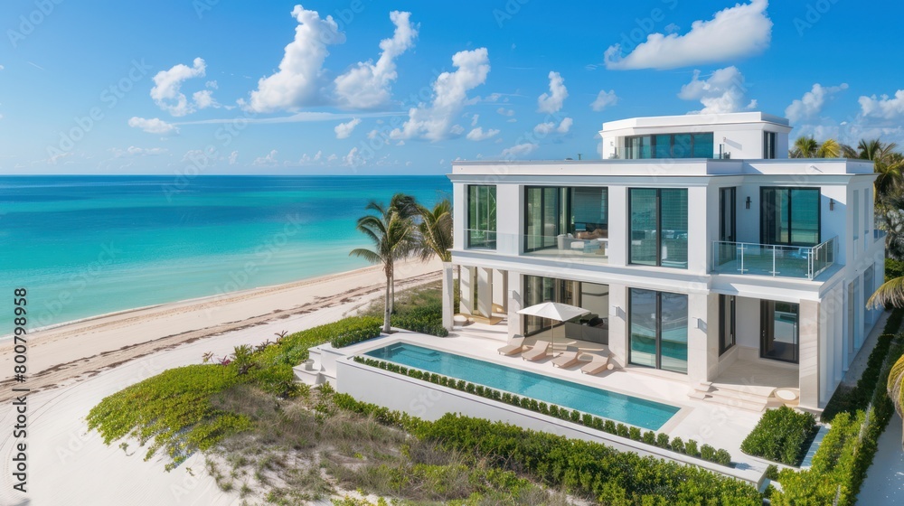 Fototapeta premium White modern resort hotel villa building on the beach with swimming pool, in beautiful daylight.