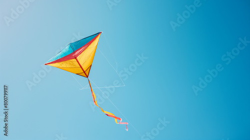 Colorful kite soaring against a clear blue sky  symbolizing freedom and joy.
