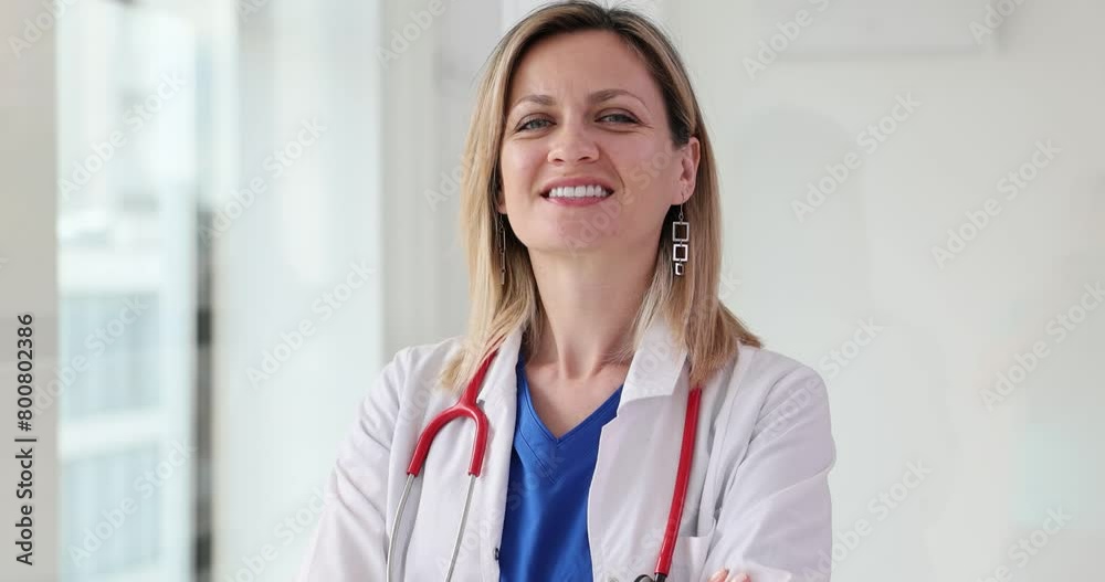Confident female doctor in a white coat smiles at camera Confident female doctor in a white coat smiles at camera