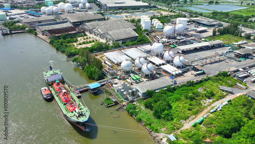 Aerial drone reveals a sprawling natural gas terminal, with tanks and pipelines stretching as far as the eye can see, nestled in an industrial landscape. Gas energy: A sustainable energy source.

