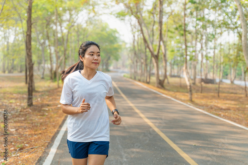 Young woman running alone in the morning at local running park in the summer