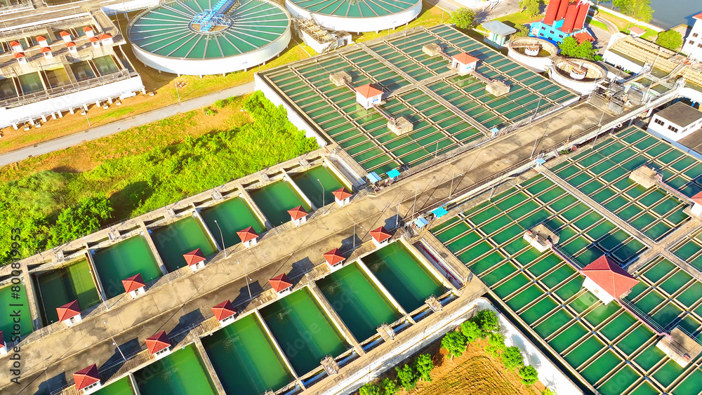 Fototapeta premium In a futuristic cityscape, a drone reveals a sleek, high-tech wastewater treatment plant, embodying innovation and sustainability, ensuring a clean, bright future for all. 
