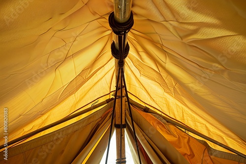 An iron pole holder hangs inside a tent being built