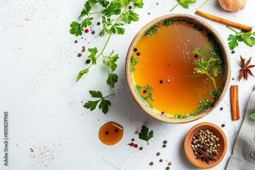 Chicken bone broth with veggies spices herbs in a bowl on light background Animal collagen Broth from meat fish veg