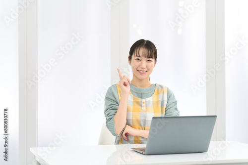 パソコン作業で良いことを思いつくエプロンを着た女性 © mapo