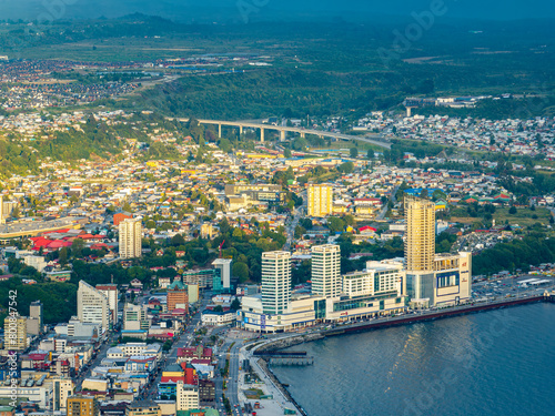 Aerial view of the city of Puerto Montt. The light that passes through the clouds generates spaces of light and shadow in the city