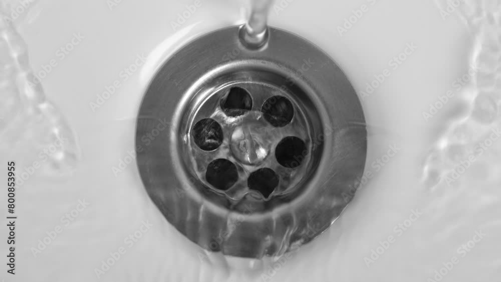 Water is running into white sink at bathroom, closeup Water is running into white sink at bathroom, closeup