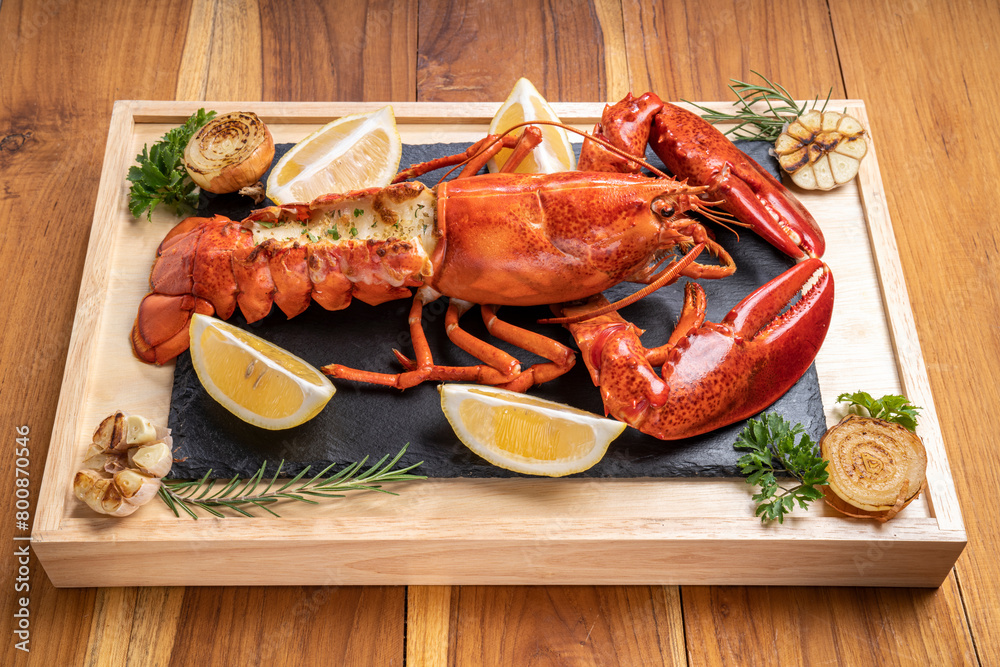 Grilled Lobster with Cheese on black plate, Grilled Canadian Lobster on wooden background. Grilled Lobster with Cheese on black plate, Grilled Canadian Lobster on wooden background.
