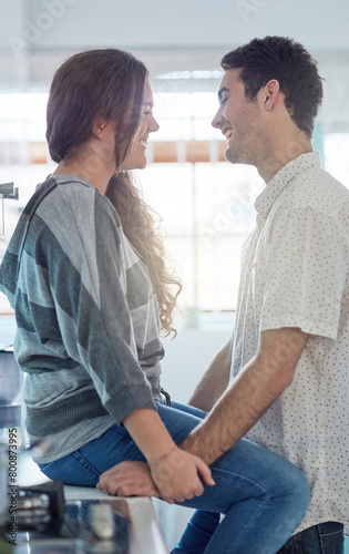 Happy, couple and love on counter in kitchen at home with bonding or relaxing by embrace or communication together. Smile, man and woman with romantic relationship for care or hug in apartment