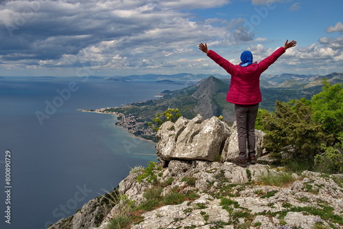 Rear view of senior woman hiking in rocky landscape with beautiful view of Adriatic sea