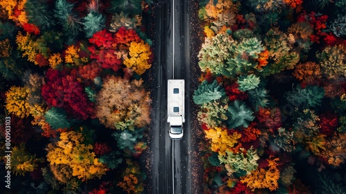 Aerial Journey Through Autumn Forest Truck Drives Along Vibrant FoliageLined Path in Tranquil Nature photo