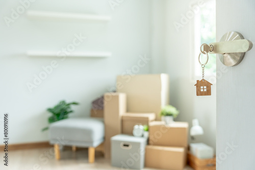 Moving house, relocation. The key was inserted into the door of the new house, inside the room was a cardboard box containing personal belongings and furniture. move in the apartment or condominium