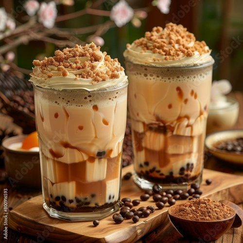 Two glasses of bubble tea with coffee jelly, topped with whipped cream and brown sugar