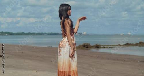 A young maiden, adorned in her beach dress, discovers the wonders of a Caribbean island's beach. photo