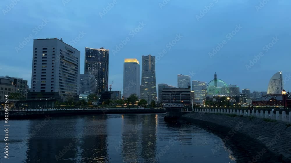 Twilight cityscape with river reflections, modern buildings glowing against dusk sky, urban tranquility Twilight cityscape with river reflections, modern buildings glowing against dusk sky, urban tranquility