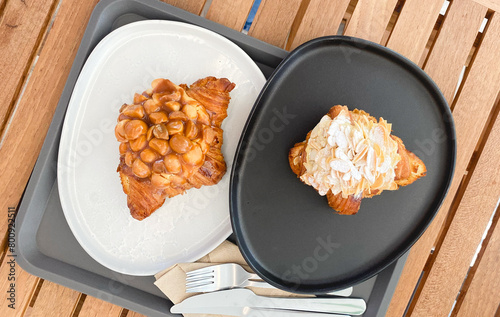 Macadamia Croissants and Almond Croissants are served on a wooden table.