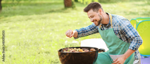 Man cooking tasty food on b...