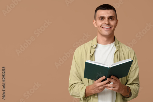 Handsome young man reading ...