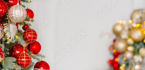 A Christmas tree decorated for the new year with toys and bows on a festive background. An elongated panoramic image for a banner in red white and gold colors