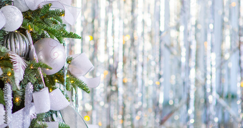 A Christmas tree decorated for the new year with toys and bows on a festive background. Elongated panoramic image for the banner in white colors