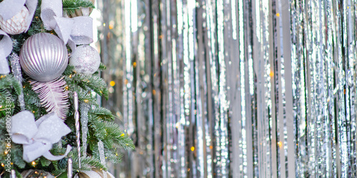 A Christmas tree decorated for the new year with toys and bows on a festive background. Elongated panoramic image for the banner in white colors