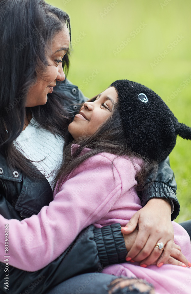 Hug, mother and daughter with smile for bonding, caring and spend time together in park. Outdoor, mom and girl with happiness for relaxing, comfort and embrace love with care while sitting in nature