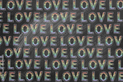 A repeating pattern of the word LOVE in rainbow colors against a chalkboard. LGBT, LGBTQIA rights and gender equality concept.