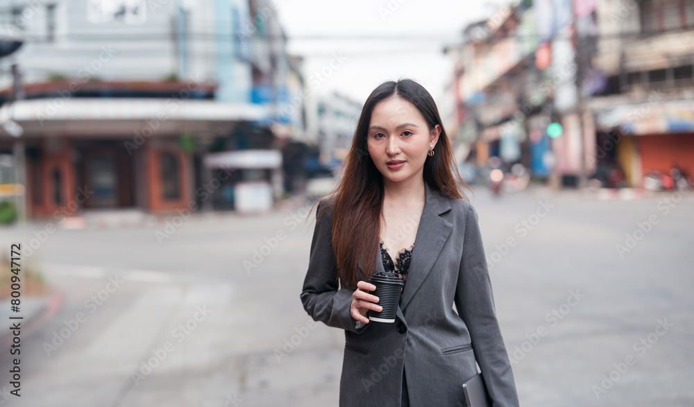 Beautiful woman going to work, businesswoman holding laptop with a cup of coffee Beautiful woman going to work, businesswoman holding laptop with a cup of coffee
