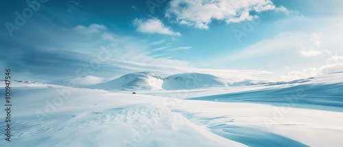 Serene Snow-Covered Landscape with Blue Skies and Rolling Hills.