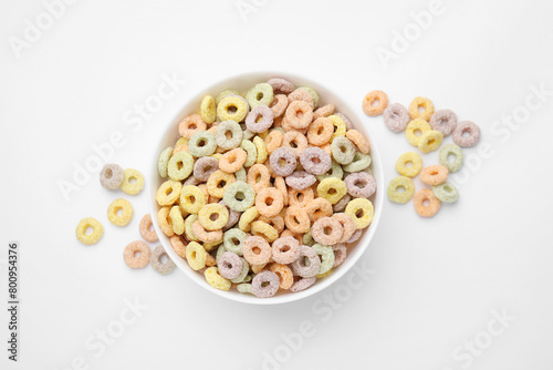 Tasty cereal rings in bowl on white table, top view