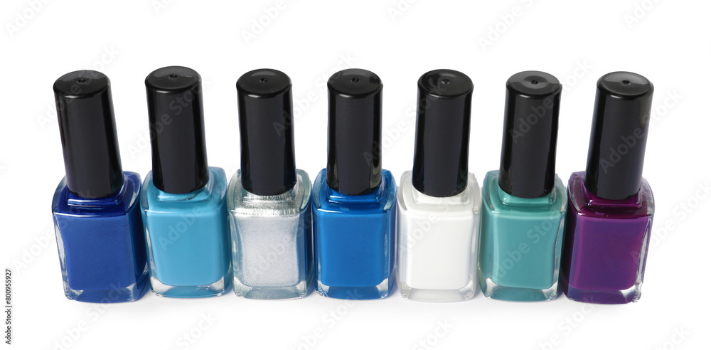 Bright nail polishes in bottles isolated on white