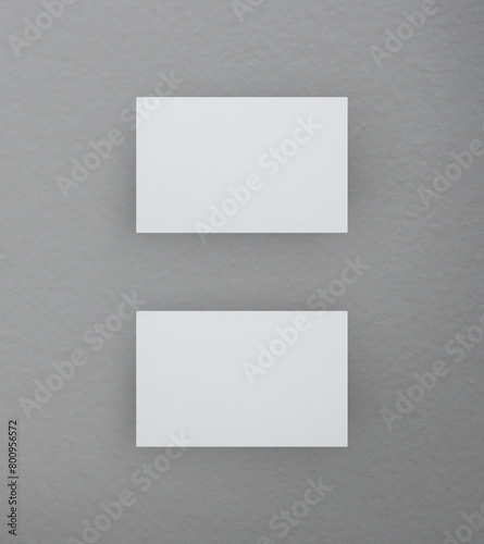 Blank white business name card mockup on grey background, Top view, 3D rendering © grapestock