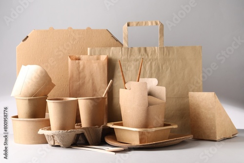 Eco friendly food packaging. Paper containers, tableware and bag on light background