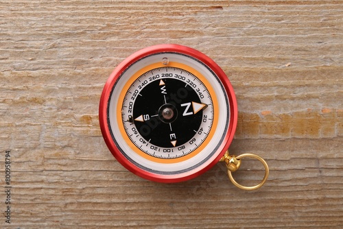 One compass on wooden table, top view