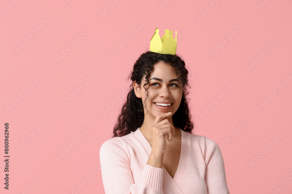 Beautiful young African-American woman in paper crown on pink background Beautiful young African-American woman in paper crown on pink background