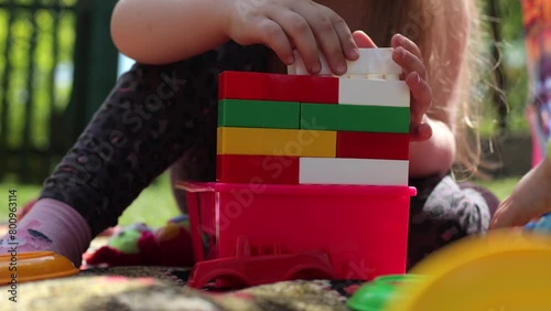 Children's cubes of different colors. The child builds a constructor, plays in the yard. Toys for preschoolers, child development. Children's entertainment