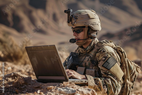photo against the backdrop of the arid desert landscape, a focused soldier employs a laptop computer and radio set for vital communication during a military operation,
