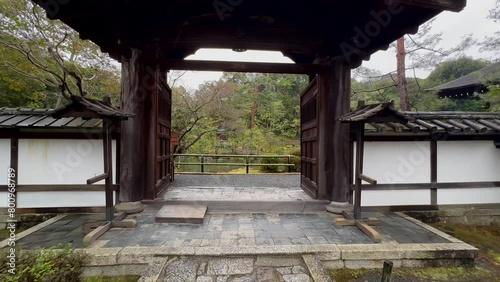 Walking Through Entrance Gate Of Konchi-in Temple Revealing Lake On Rainy Day. Kyoto, Japan. POV, handheld photo