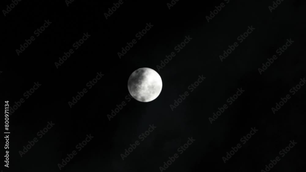 Full moon with moving black clouds. Clouds floating through the bright disk of the moon. Mysterious night scene Full moon with moving black clouds. Clouds floating through the bright disk of the moon. Mysterious night scene