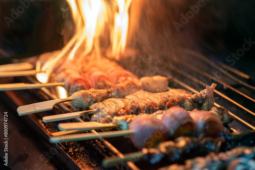 A photo of some meat skewers being grilled over an open flame.