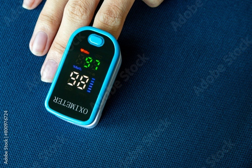 oxygen meter, Patients use fingertip oximeter, measuring oxygen levels as basic health check.