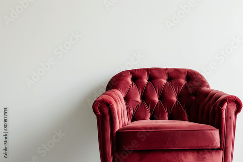 A velvet armchair in a rich burgundy color, showcased on a solid white backdrop.