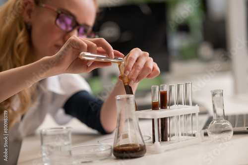 Caucasian woman in a medical gown doing laboratory experiments. 