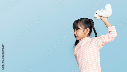 Little girl is throwing dolls and destroying things. little girl is angry.