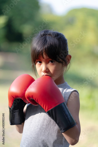 A little girl is practicing fighting, boxing, exercise, determined, strong © Cheangchai