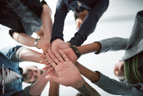 Hands, huddle and unity with designer people in office from below for collaboration, support or trust. Goals, motivation and target with palm of design group closeup in workplace for team building